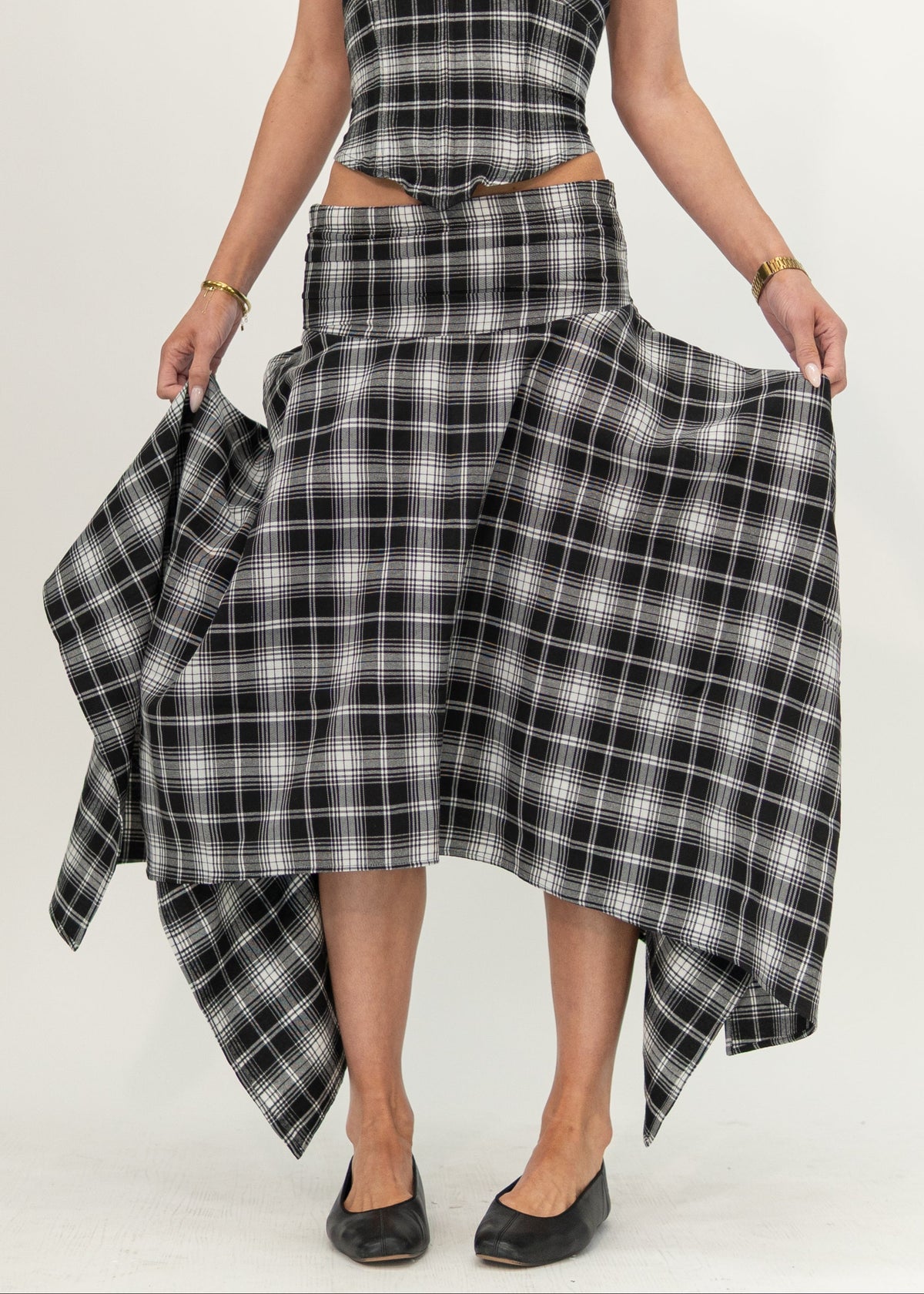 Mila Skirt in black and white plaid, front view showing the fitted hip yoke and asymmetric handkerchief hem, styled with the matching Alba Plaid top